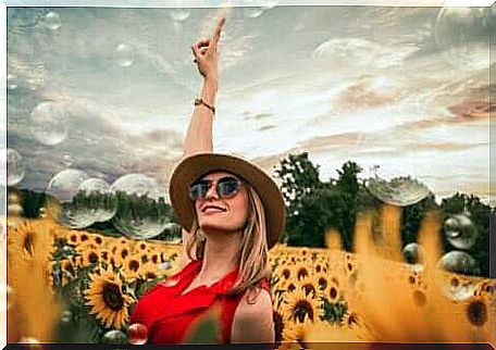 A happy woman in a field of sunflowers.