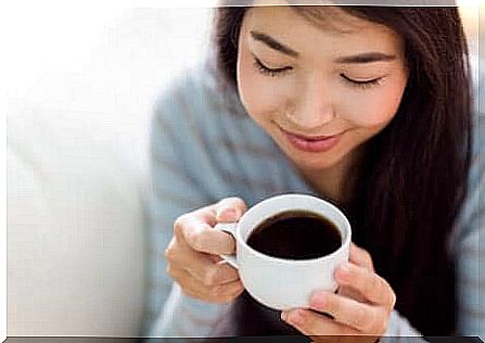 A woman drinking a hot drink.
