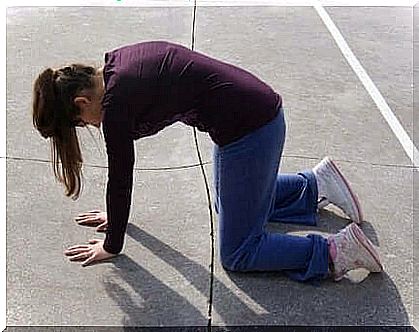 A woman performs an exercise on the floor.