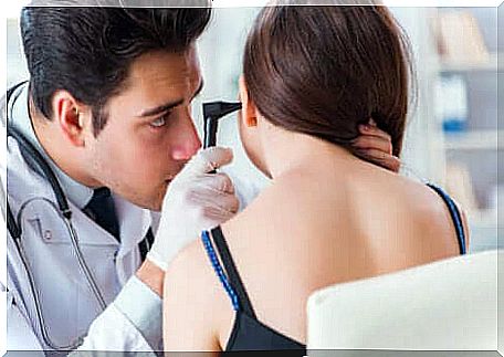 A doctor examining a woman's ears. 