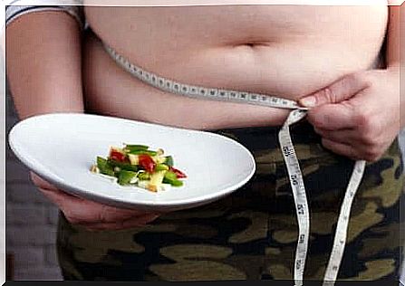 An obese belly in front of a slimming plate. 